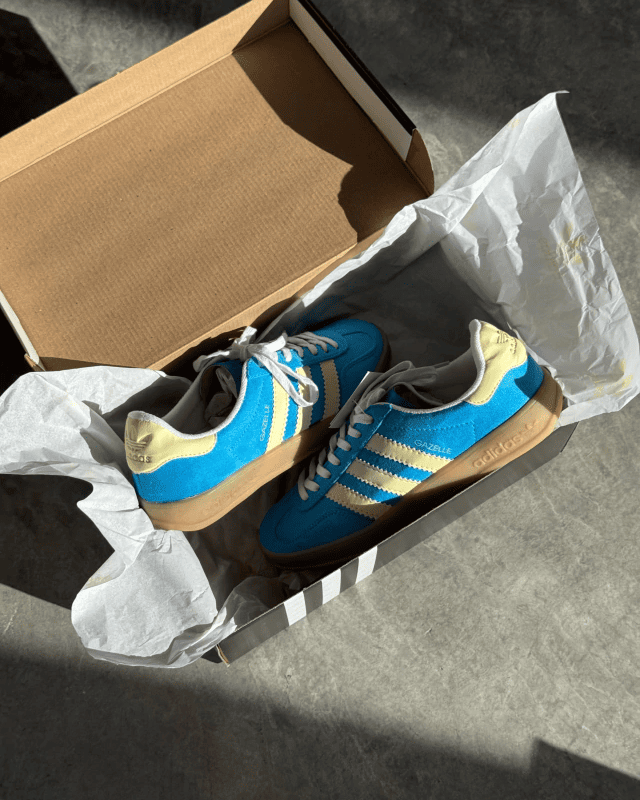 Tênis Gazelle Indoor azul com detalhes amarelo manteiga e solado caramelo