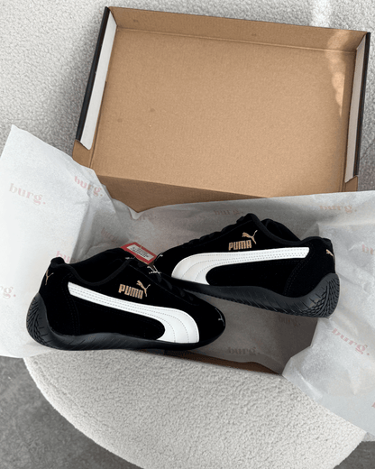 Tênis Speed Cat preto feminino em suede com detalhe off-white e logo dourado