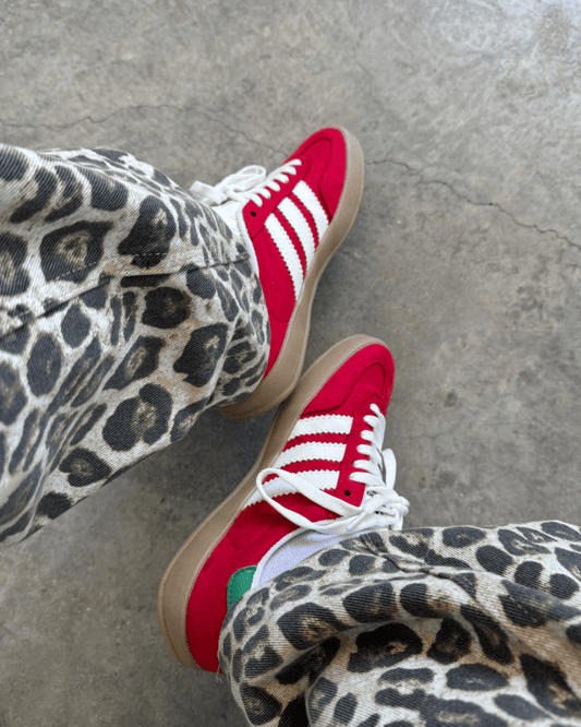 Tênis Gazelle Indoor vermelho com listras brancas e detalhe verde no calcanhar