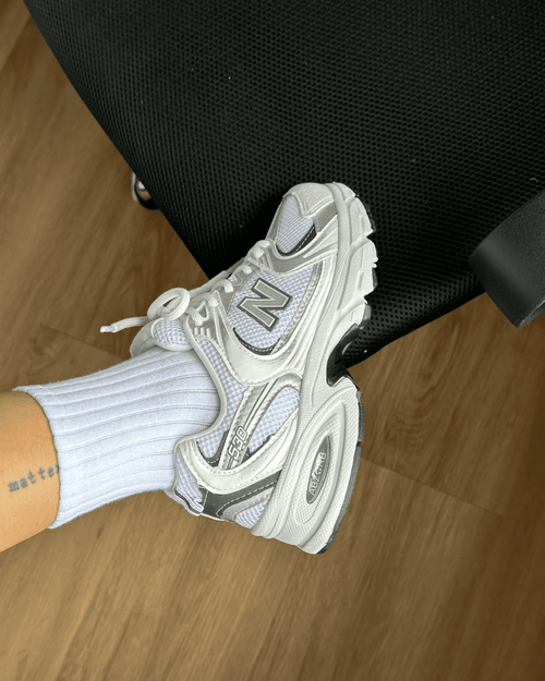 Tênis NB 530 branco feminino com detalhes prata e solado anatômico